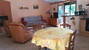 Un salon confortable avec un canapé, une table à manger et un coin cuisine avec une fenêtre.
