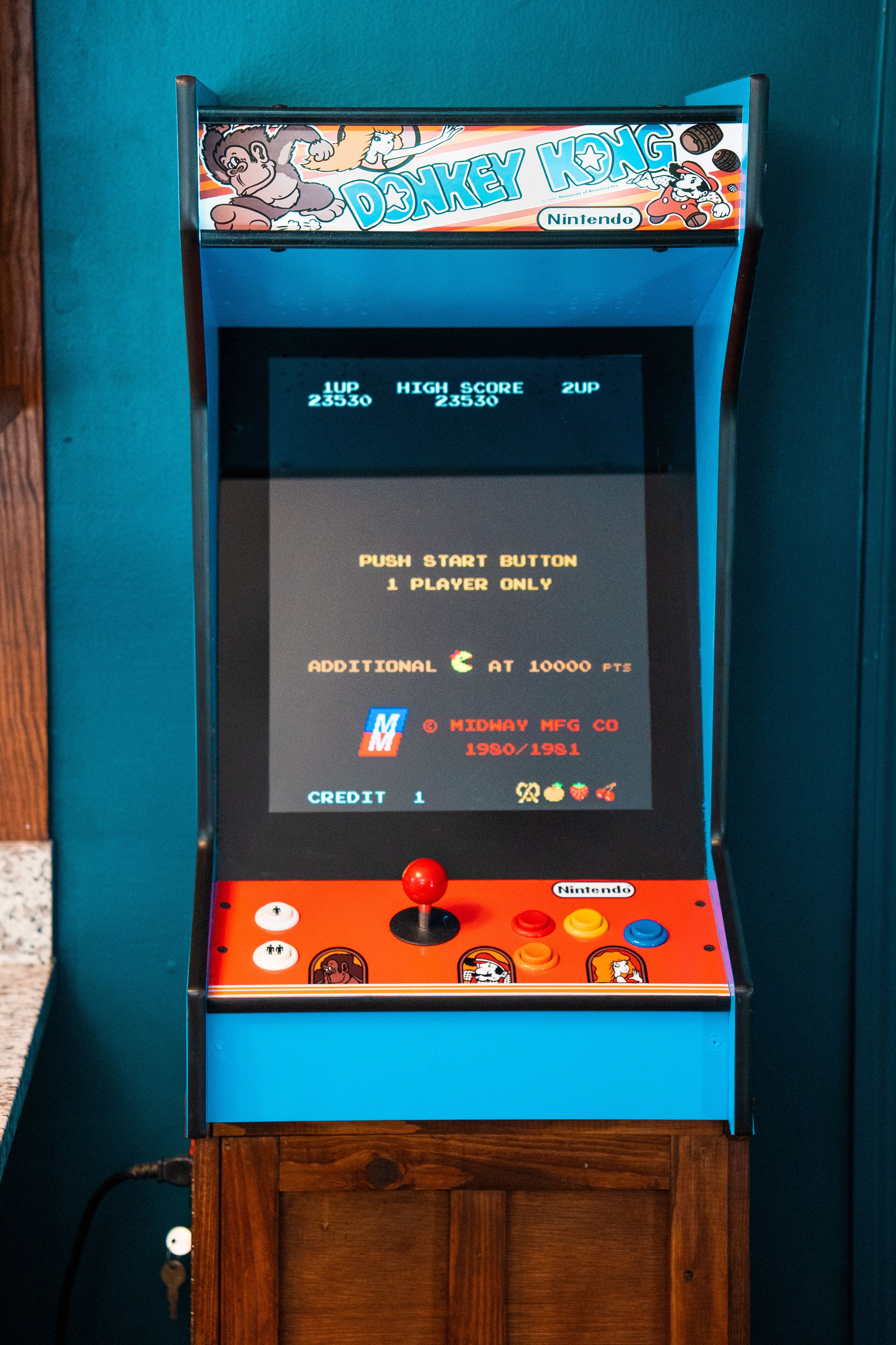 A vintage arcade machine with a blue and orange color scheme, featuring the 'Donkey Kong' logo and a score display.