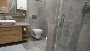 Ein modernes Badezimmer mit Waschbecken, Toilette und Duschbereich.
