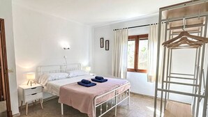 Una camera da letto con un letto, comodini, un armadio a muro e una finestra con tende.