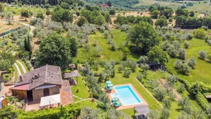 Une villa avec piscine, entourée d’une végétation luxuriante et de collines.