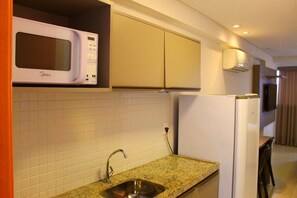 A compact kitchen with a microwave, a sink, and a refrigerator.
