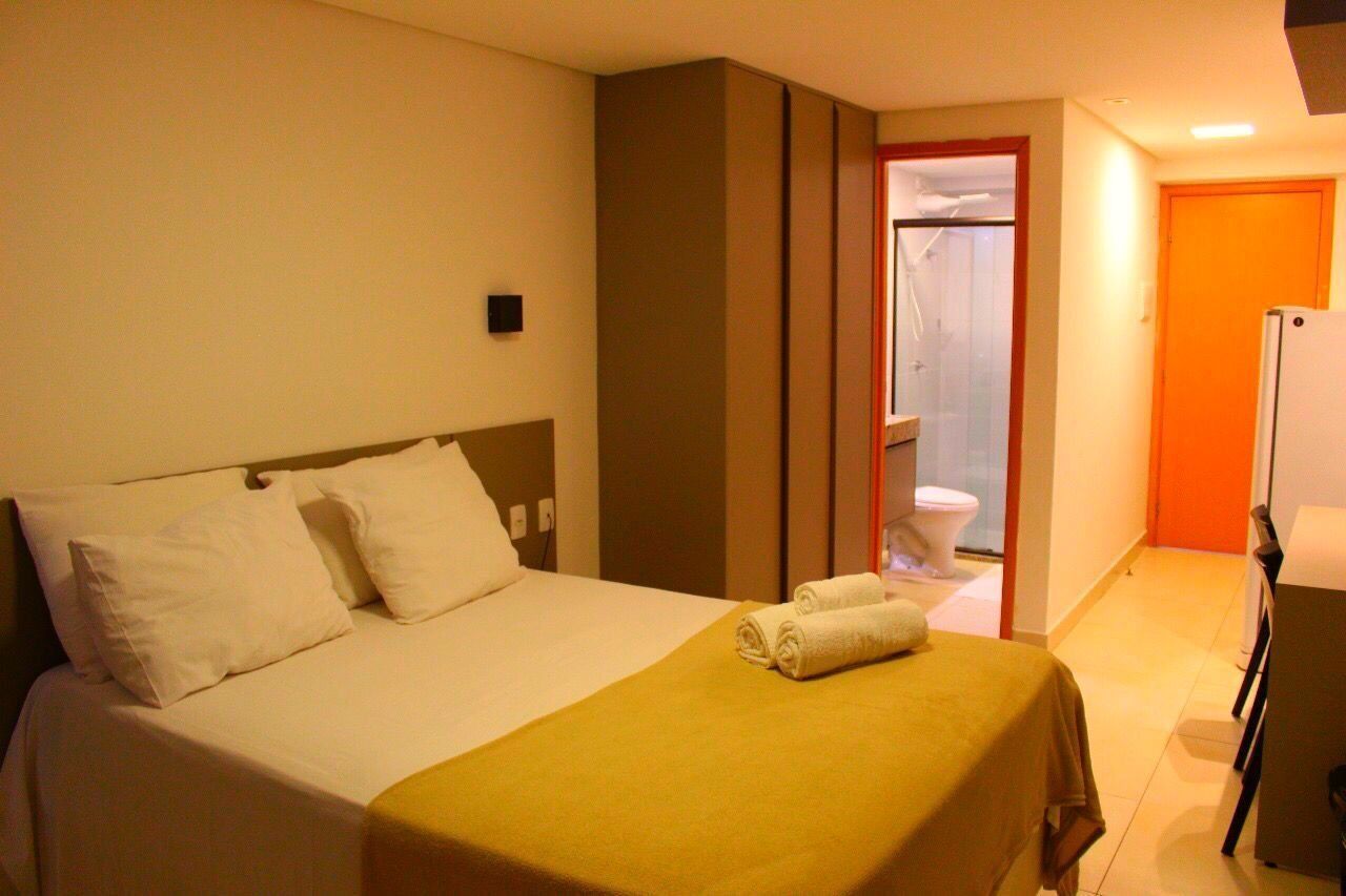 Une chambre d’hôtel avec un lit, une salle de bain et un réfrigérateur.