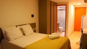 Une chambre d’hôtel avec un lit, une salle de bain et un réfrigérateur.