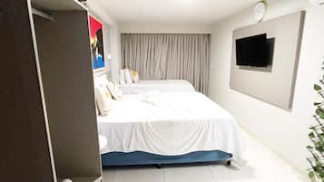 Een moderne hotelkamer met een groot bed, een flatscreen televisie aan de wand en een inbouwkleerkast.