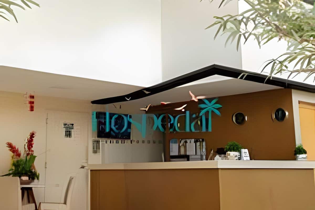 A modern reception area with a glass ceiling, a reception desk, and indoor plants.