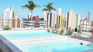 A rooftop swimming pool with a cityscape view. - Manaira Apart Hotel (João Pessoa)