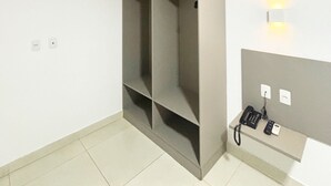 A room with a built-in wardrobe, a wall-mounted telephone, and a light fixture. - Manaira Apart Hotel (João Pessoa)
