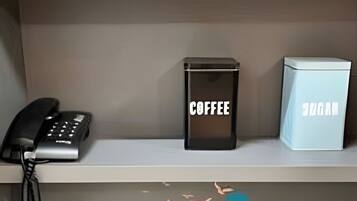 Un comptoir de réception d’hôtel équipé d’un téléphone, d’une machine à café et d’un mini-bar.