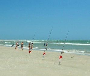 A beach with fishing rods and people.