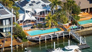 Un complexe hôtelier moderne doté d’une piscine, d’un port d’attache pour bateaux et offrant une vue sur l’eau.