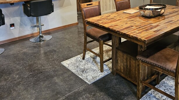 Un comedor con una mesa de madera, sillas y una araña.
