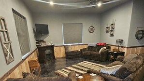 Una sala de estar acogedora con chimenea, asientos cómodos y un televisor de pantalla plana.