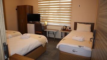 A hotel room with two beds, a desk, a television, and a wardrobe.