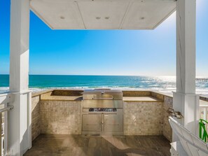 A covered outdoor grill area with a view of the ocean. - Big Blue -Mini-Resort, Movie Theater, Pools, Hot Tub, Beach Front, Sleeps 28! (Surf City)