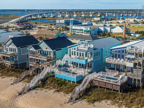 Un complejo turístico frente al mar con edificios de varios pisos, balcones y un paseo que da acceso a la playa.
