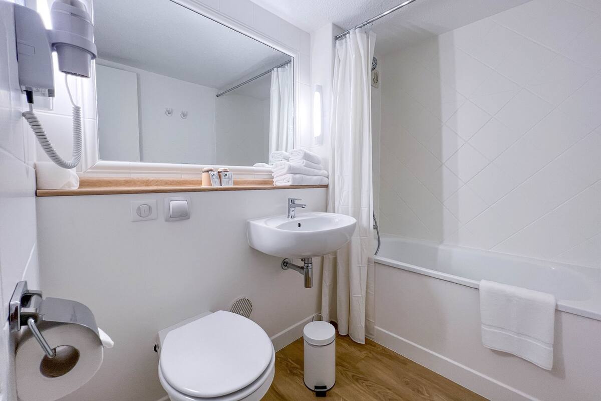 Une salle de bain moderne équipée de toilettes, d’un lavabo et d’une douche.