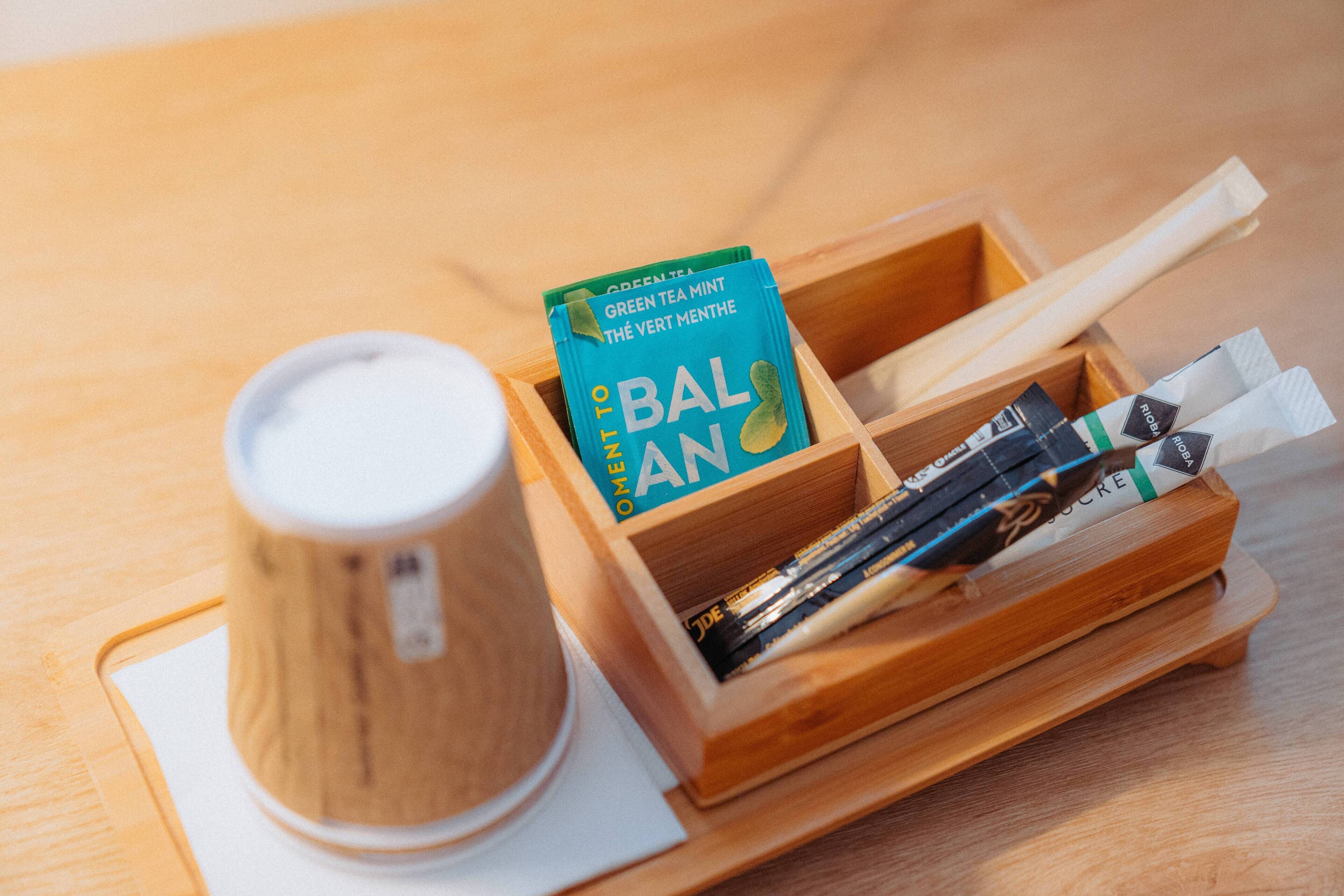 Een houten dienblad met een kop en een theekist.