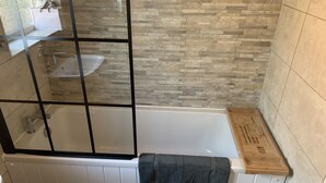 Une salle de bain moderne avec une douche à parois de verre, une baignoire blanche et un meuble-lavabo en bois.