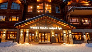 A large wooden lodge with a stone facade and a sign reading "WHITE PEARL Lodge & Spa". - CGH Résidence & Spa White Pearl Lodge (La Plagne-Tarentaise)