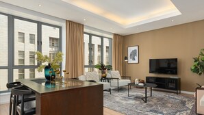 A modern living room with a large window, a sofa, a TV, and a dining area. - Sleek Designer Apartment in the heart of Cape Town (Cape Town)