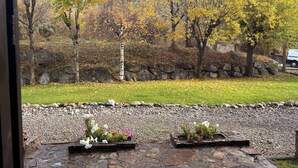 Un sendero de piedra que conduce a un jardín con vistas a árboles y un muro de piedra.