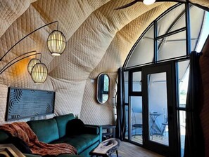 Relax in this inviting space with a curved ceiling, comfortable sofa, and dining area.