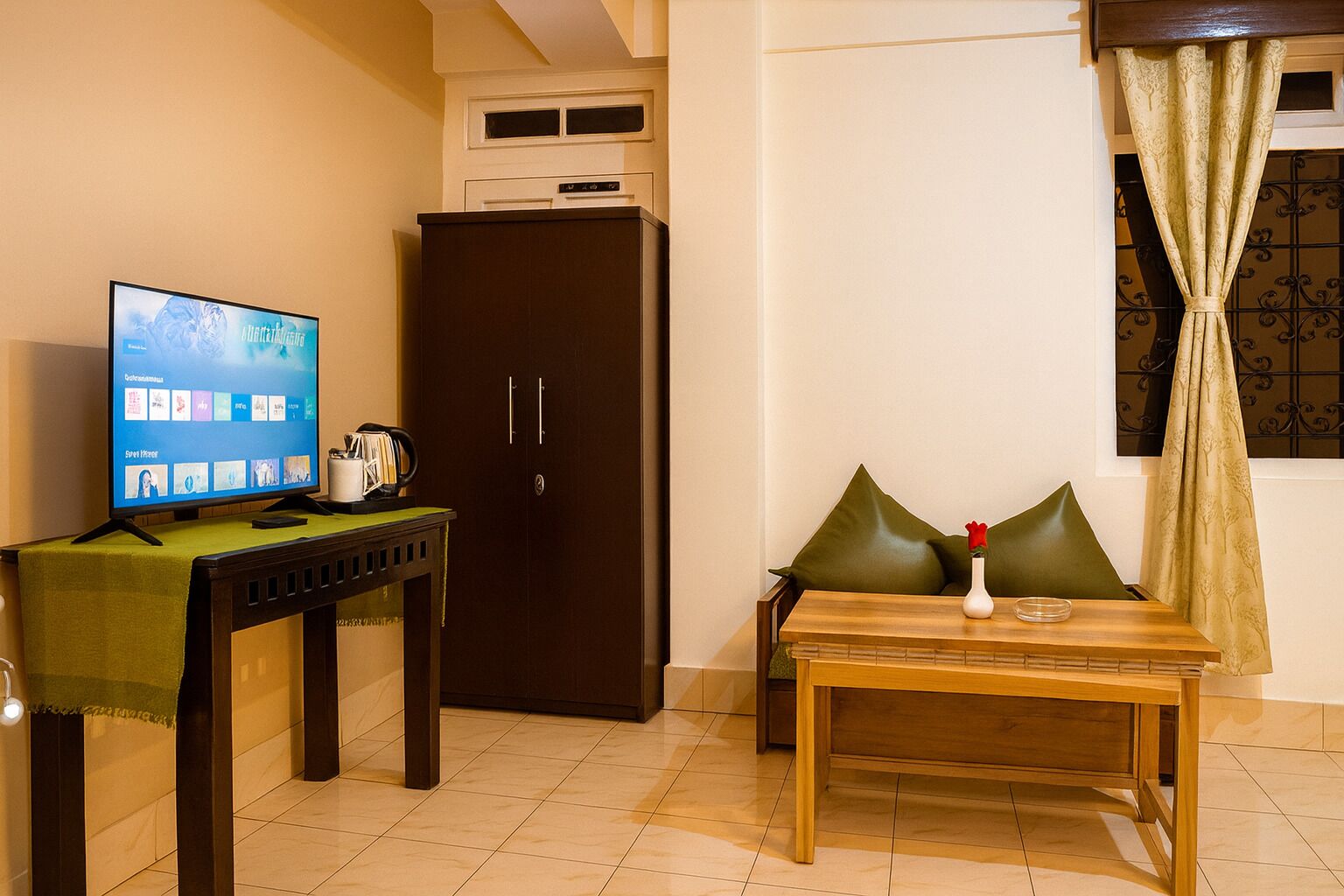 Una habitación con una mesa de madera, un televisor sobre un mueble bajo, un armario de madera oscura y una ventana con cortinas.