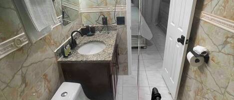Un baño con inodoro, lavabo y espejo.