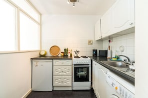 Enjoy cooking in this well-equipped kitchen with a refrigerator, stove, kettle, microwave, and dishwasher.