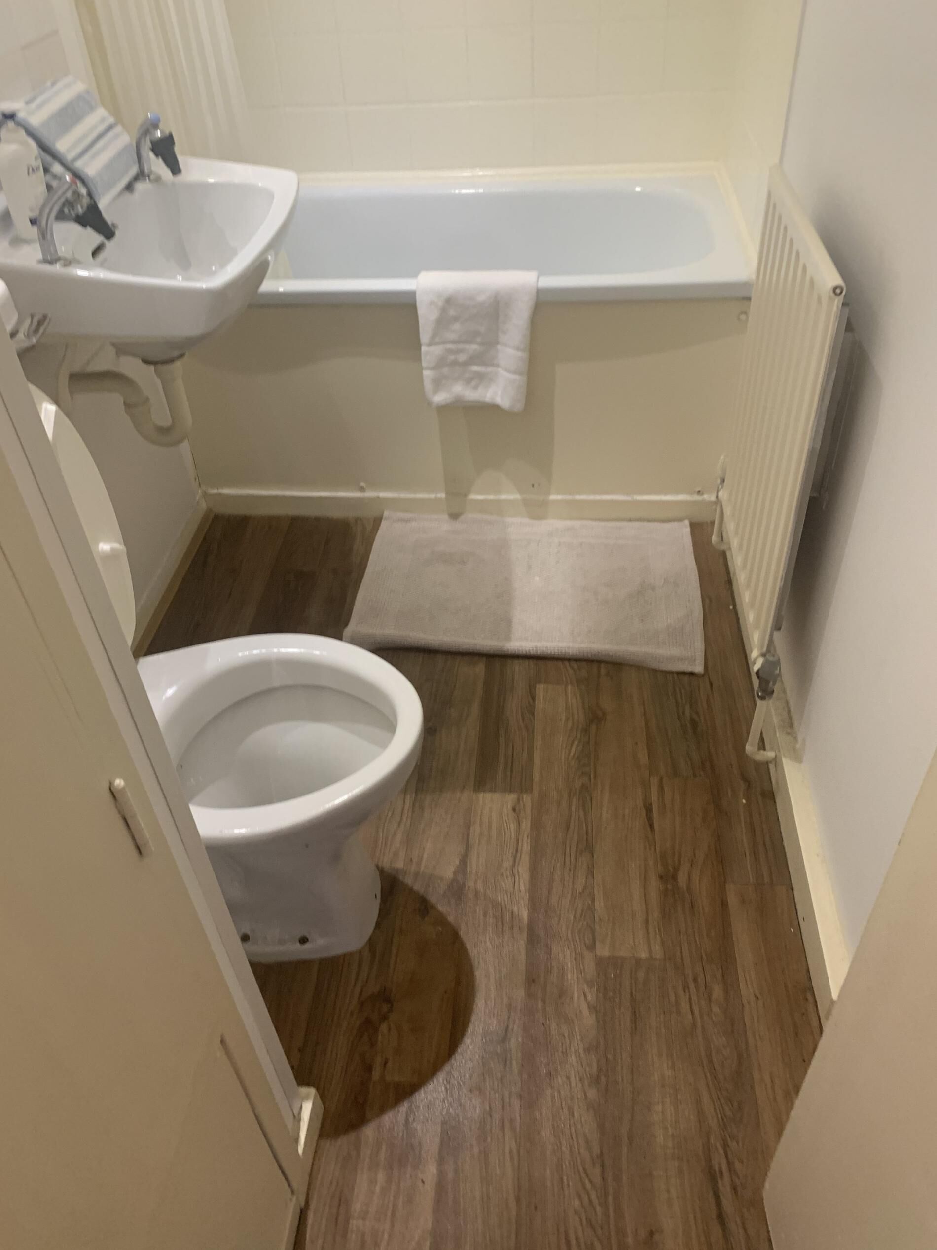 A bathroom with a toilet, sink, and bathtub.