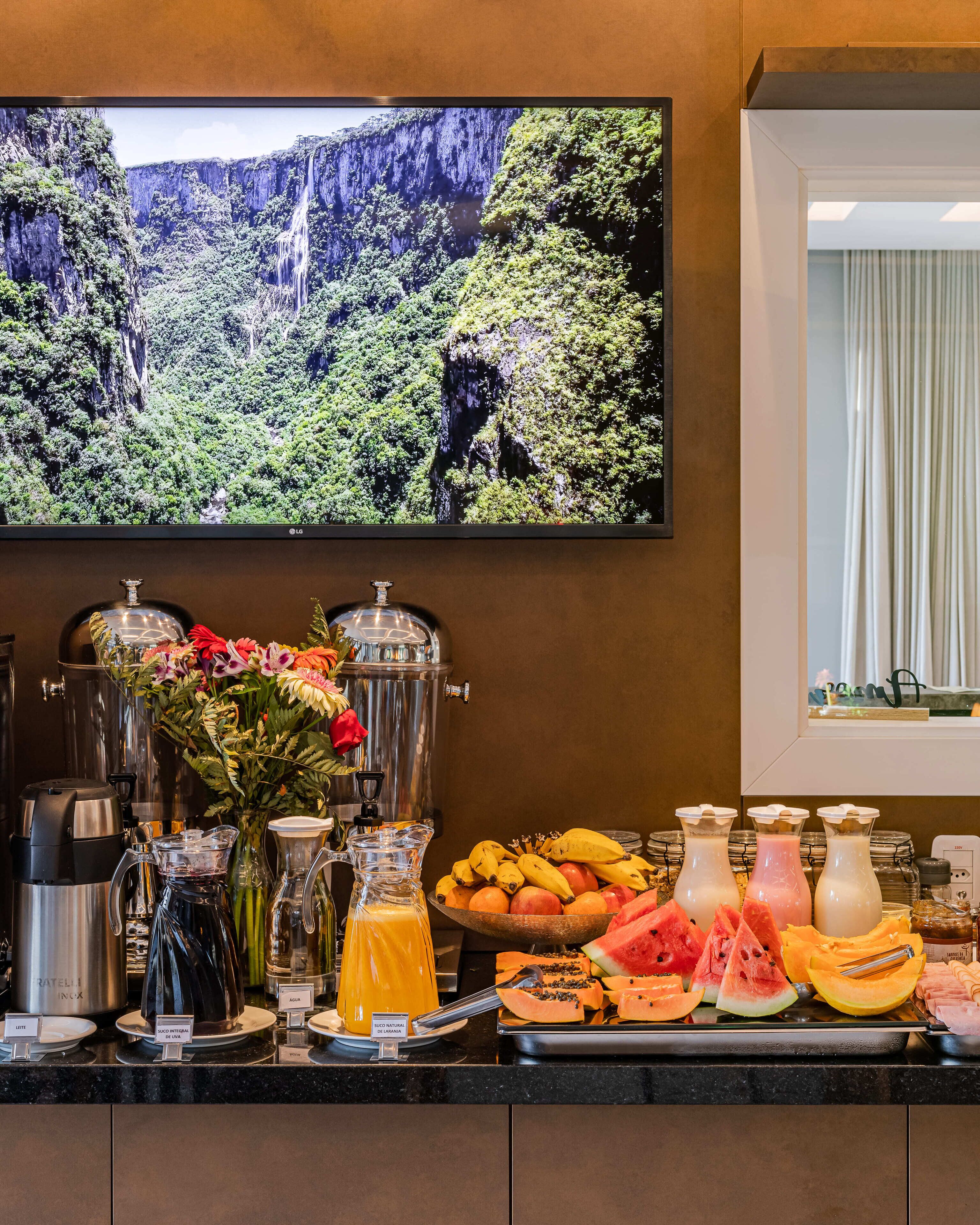 Un buffet de petit-déjeuner proposant une variété de fruits, de jus de fruits et un coin café.