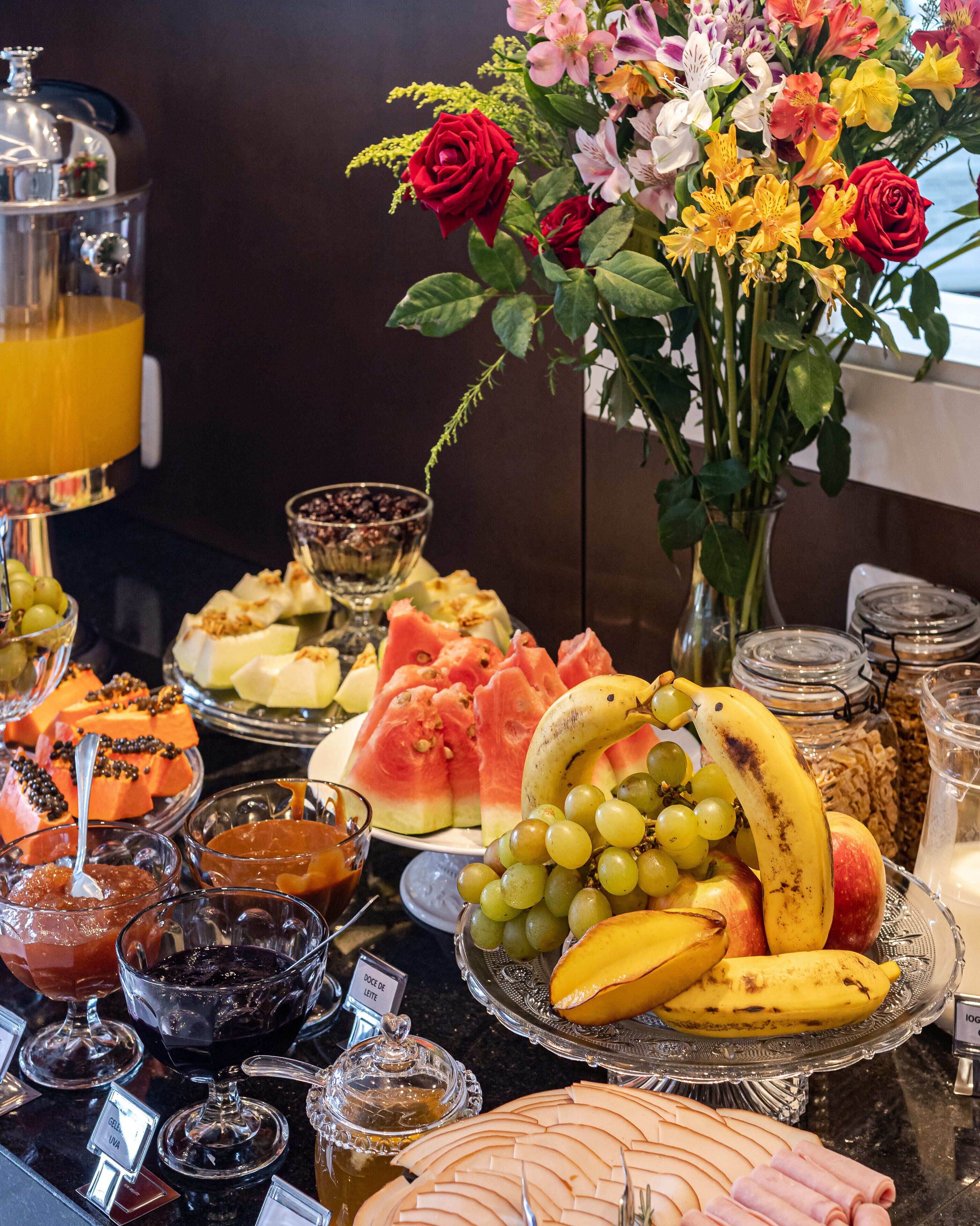 A buffet with various food items, including fruits, vegetables, and a selection of cheeses.
