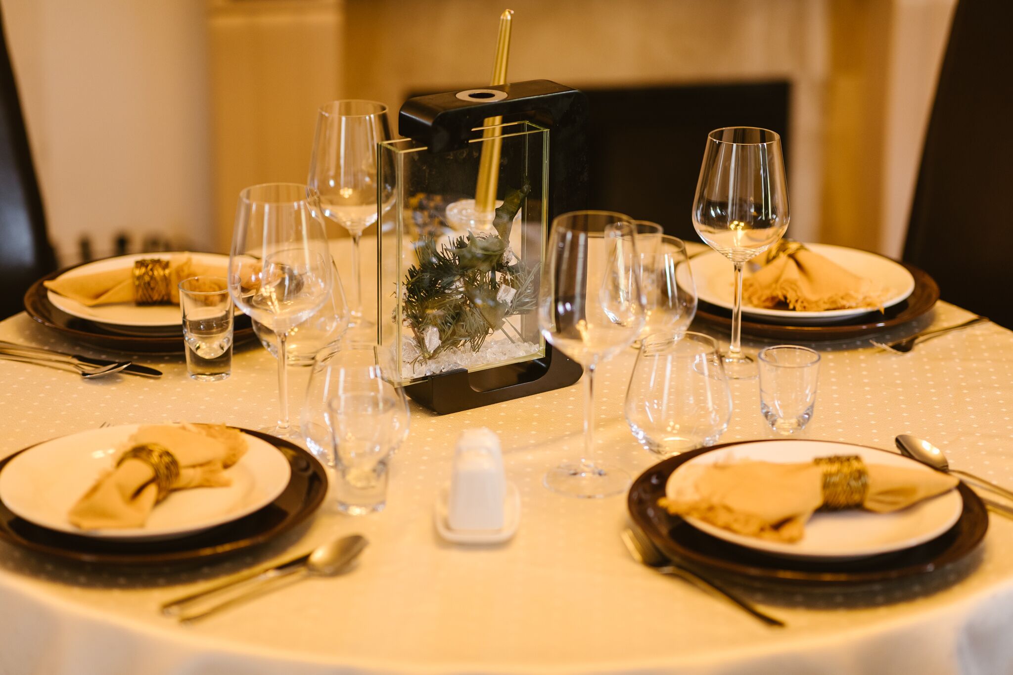A formal dining table set with multiple wine glasses, plates, and cutlery.