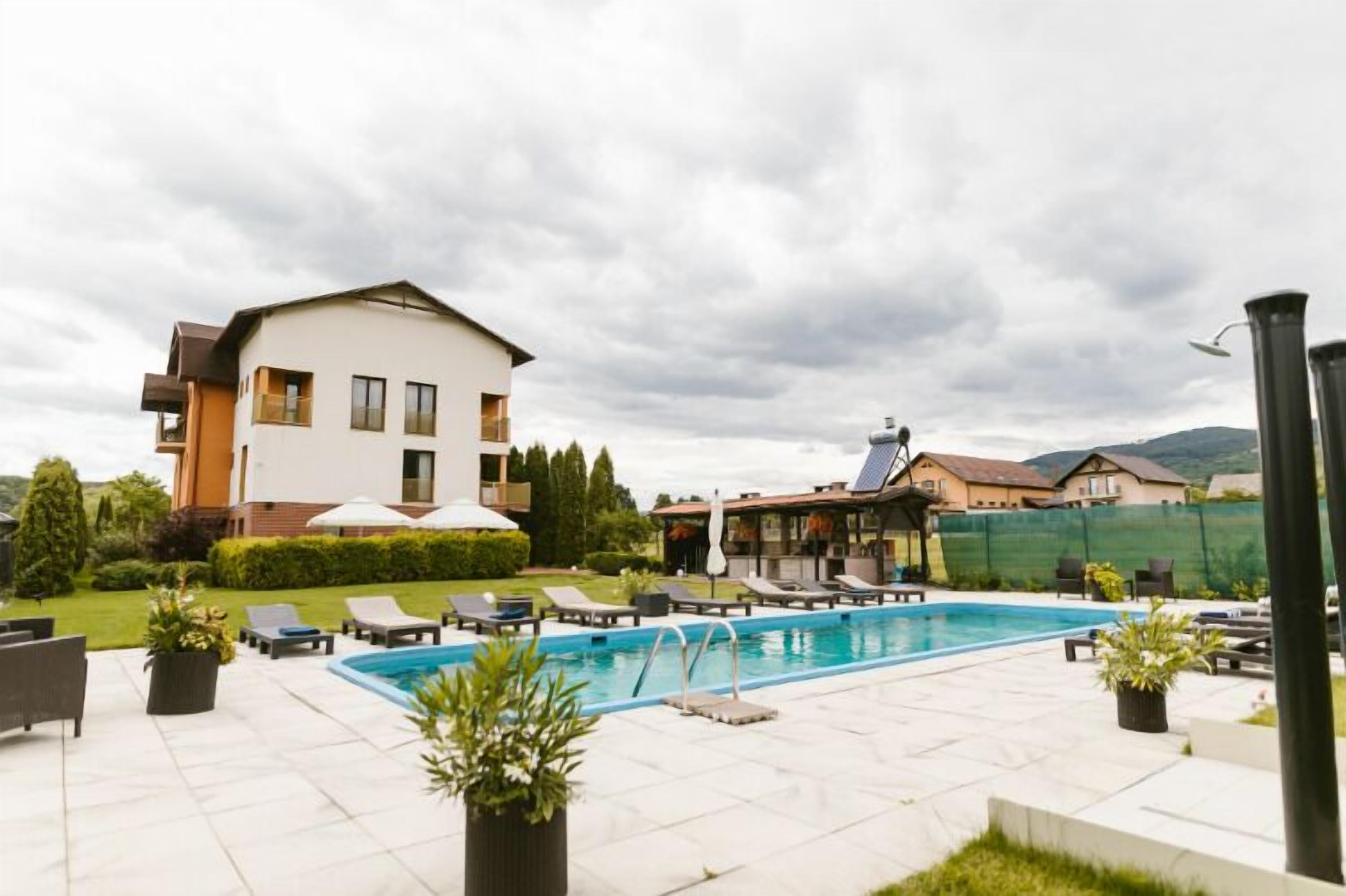 A pool area with lounge chairs and a large building in the background.