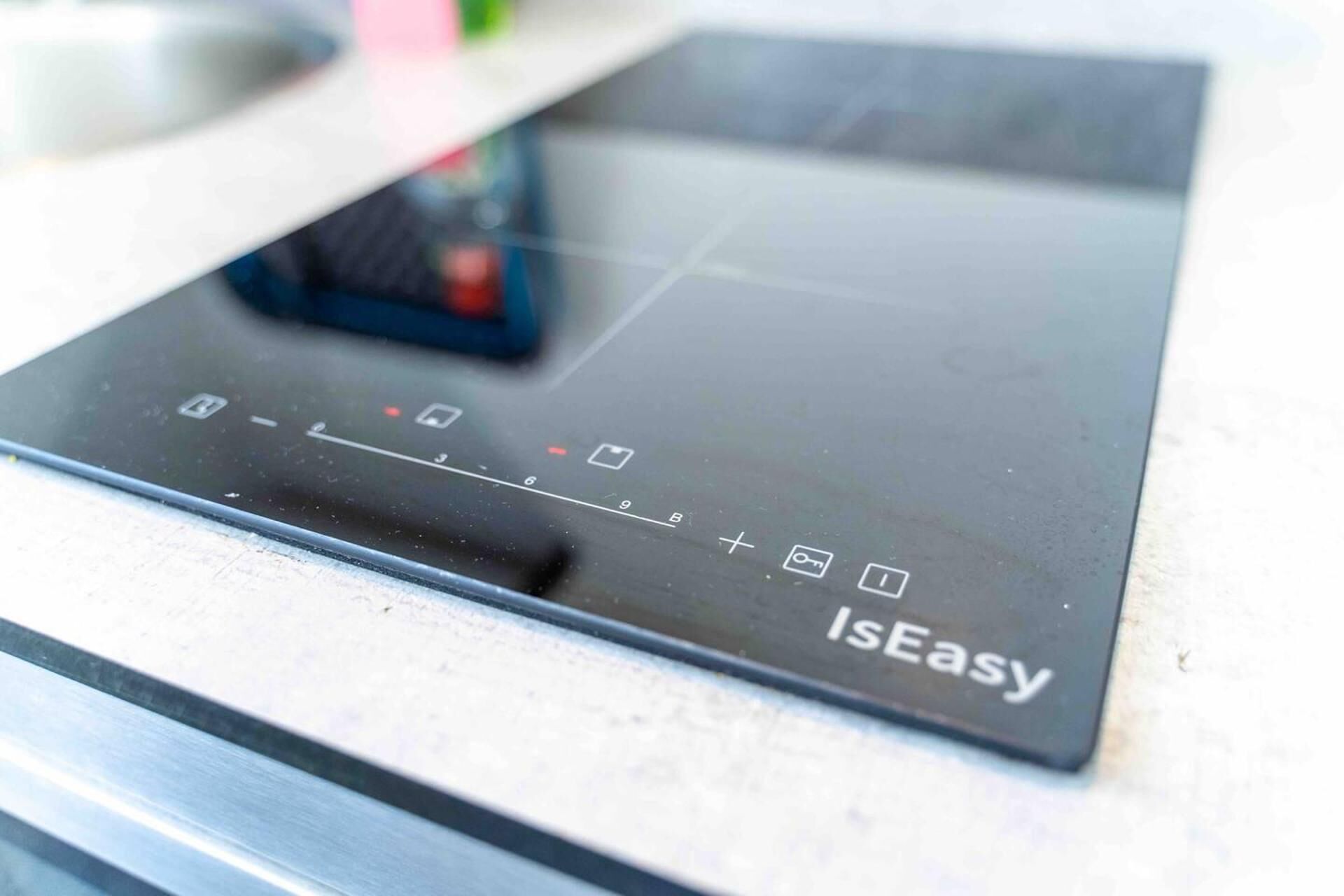A black induction cooktop with a control panel labeled "IsEasy."