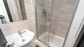 A modern bathroom with a glass-enclosed shower, a white sink, and a mirror. - Cosy Ensuite Style Studio Close to University! (Birmingham)