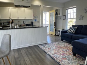 Relax in this inviting living space with a kitchen area, featuring a kitchen counter, kettle, and comfortable seating.
