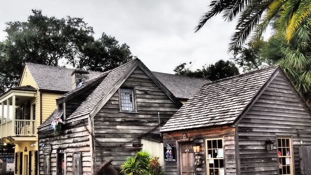 A rustic wooden building with a porch and a small garden area.