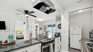 A modern kitchen with a central island, built-in oven, microwave, and refrigerator.