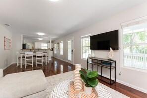 Relax in this spacious living area with a large flat-screen TV, comfortable sofa, and dining area.