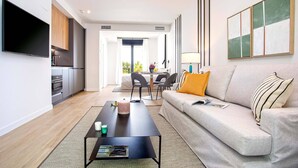 A modern living room with a sofa, coffee table, and a flat-screen TV. - Genteel Home Arruzafa II (Cordoba)