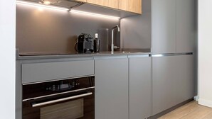 A modern kitchen with stainless steel appliances, wooden cabinets, and a sleek countertop. - Genteel Home Arruzafa II (Cordoba)