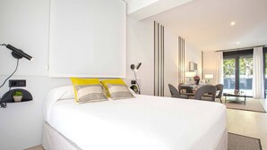 A modern hotel room with a large bed, a desk, and a chair. - Genteel Home Arruzafa II (Cordoba)