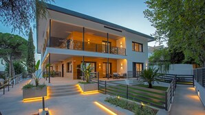 A modern two-story house with a balcony, outdoor seating area, and a well-lit pathway. - Genteel Home Arruzafa II (Cordoba)