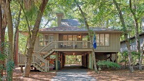A wooden cabin with a covered walkway and a staircase leading to a deck. - Stunning renovated cottage in Inlet Cove (Kiawah Island)