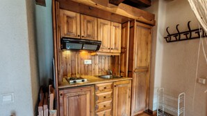 A wooden kitchen with a built-in stove, cabinets, and a small sink. - Spacious apartment with garden Cosmos 1 (Pla de l'Ermita)