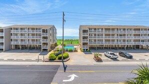 A multi-story motel with a pool and parking area.