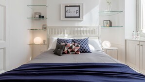 A neatly arranged bedroom with a bed, bedside tables, and shelves. - JOIVY Lovely Flat For 5 Close To Sforzesco Castle (Milan)