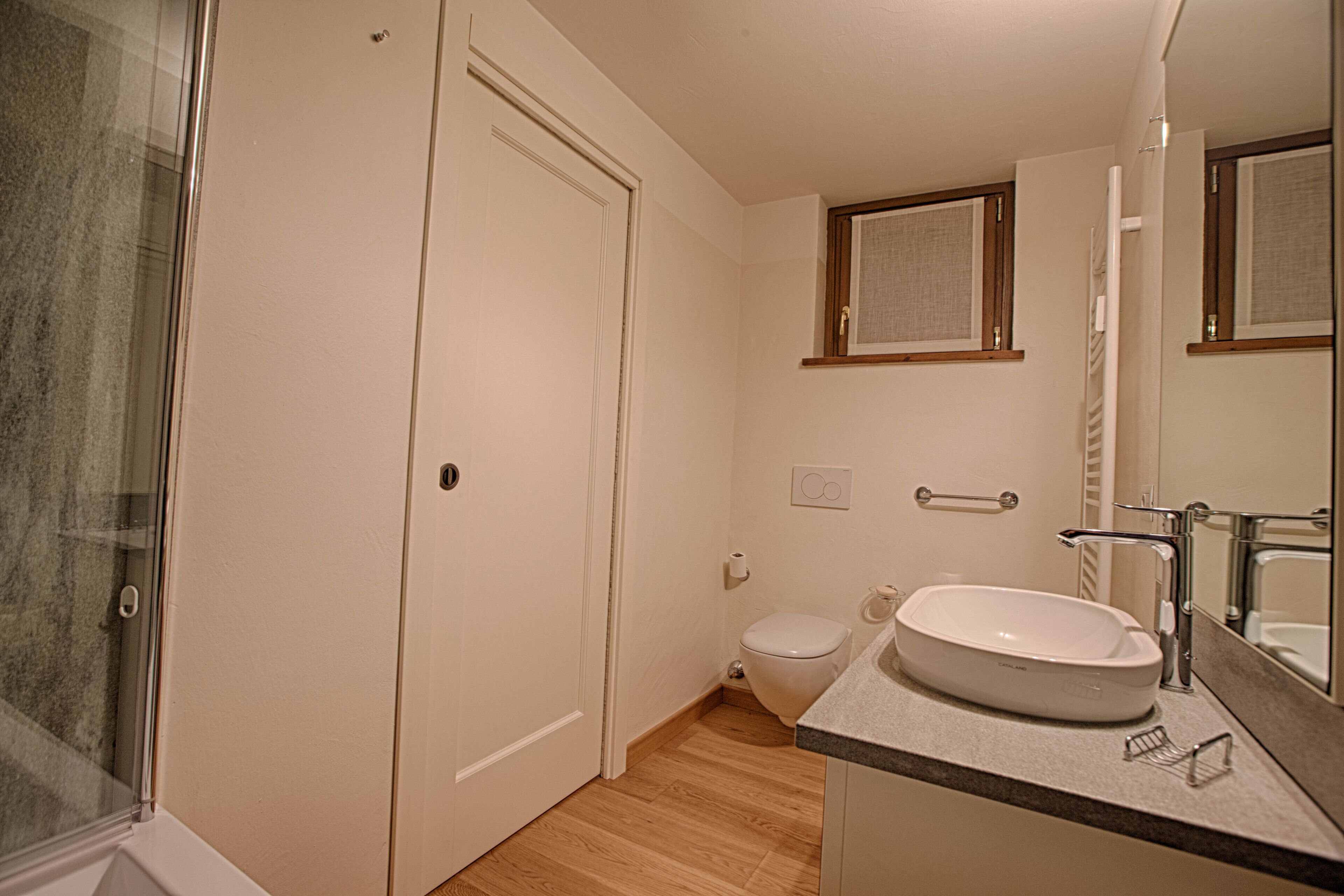 A bathroom with a toilet, sink, and shower.